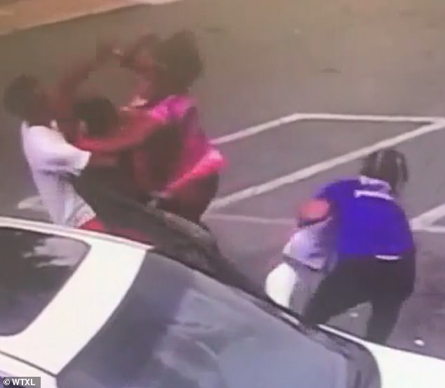 It took several seconds, while the two women and a man (left) kept tussling, until another person (right in blue) ran over to scoop up the baby