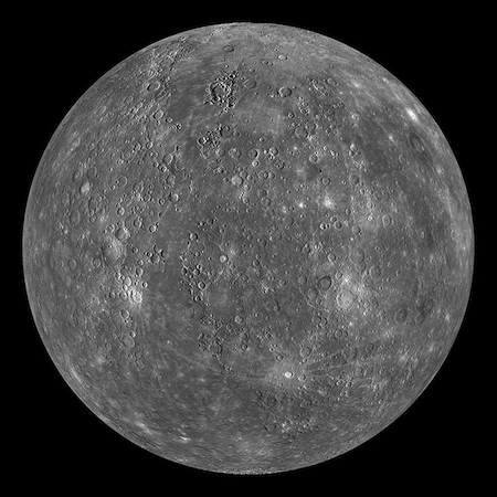 A photo of one whole lit side of Mercury. It has craters and lightly colored splotches.