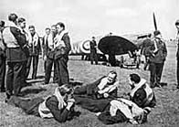 Black and white photograph showing a group of RAF pilots by a plane